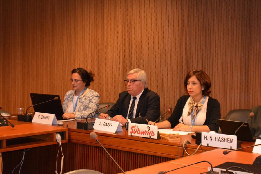 Panel discussion with speakers seated at a table with name cards