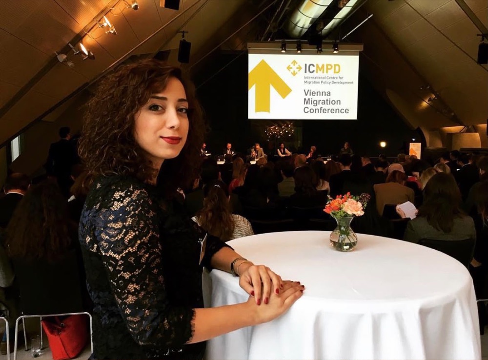 Parastoo Fatemi at the Vienna Migration Conference, with the ICMPD slide and a full hall behind her
