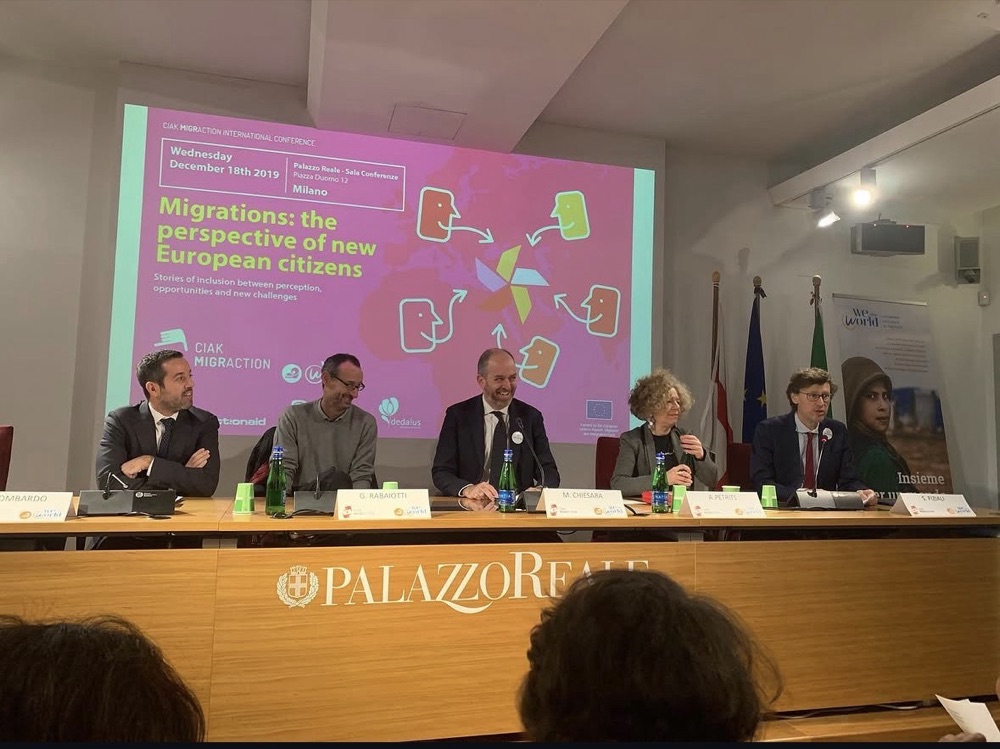 Opening panel in front of the slide: CIAK MIGRACTION International Conference, Migrations: the perspective of new European citizens, 18 December 2019, Palazzo Reale, Milan