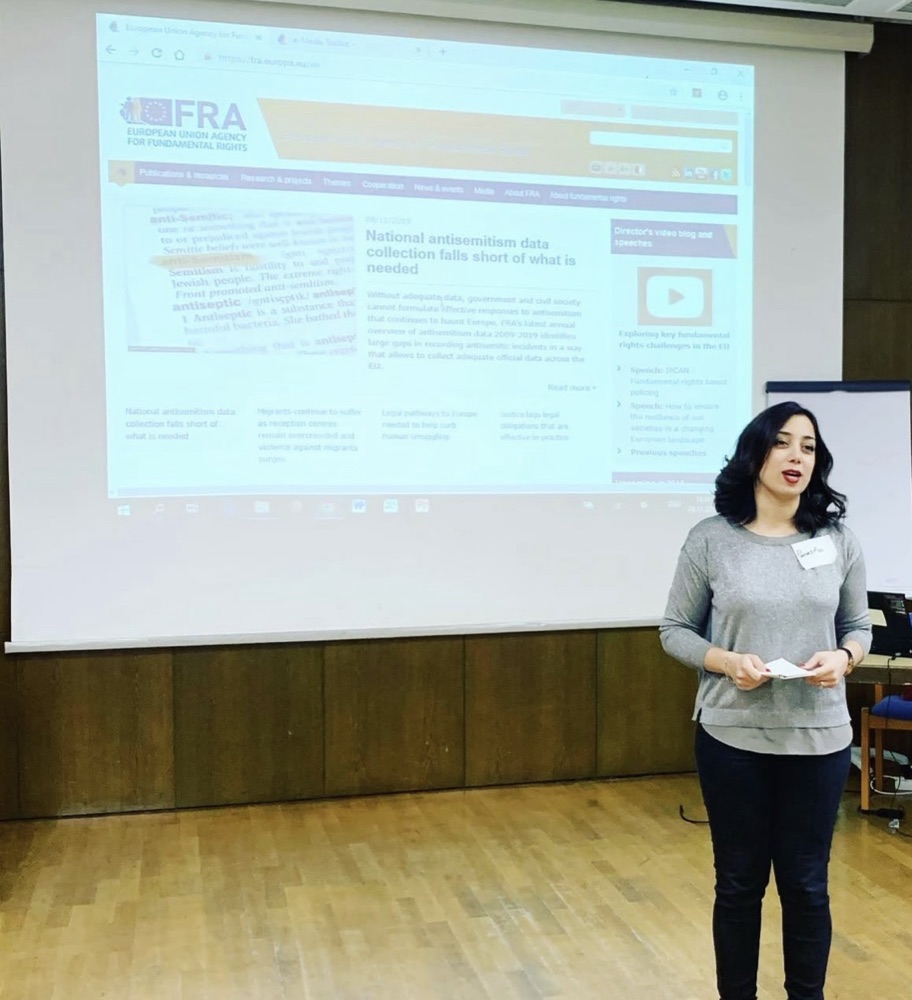 Parastoo Fatemi presenting at the journalists' workshop in front of the projected FRA website